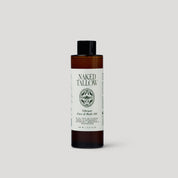 Bottle of Naked Tallow oil on a light gray background